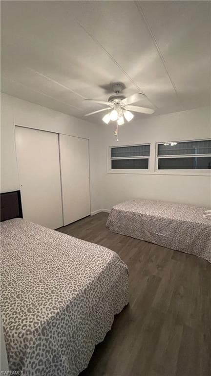 Bedroom with ceiling fan, vinyl flooring, and a closet
