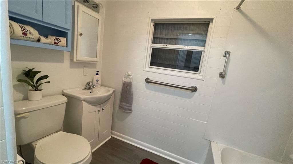 Bathroom featuring vinyl flooring, toilet, and vanity