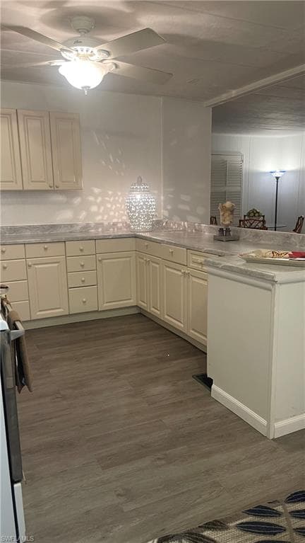 Kitchen featuring ceiling fan, stove, and vinyl flooring