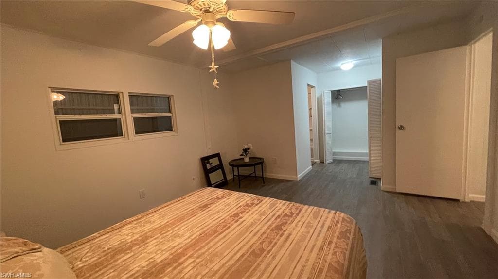 Master bedroom featuring a closet, ceiling fan, and dark vinyl floors