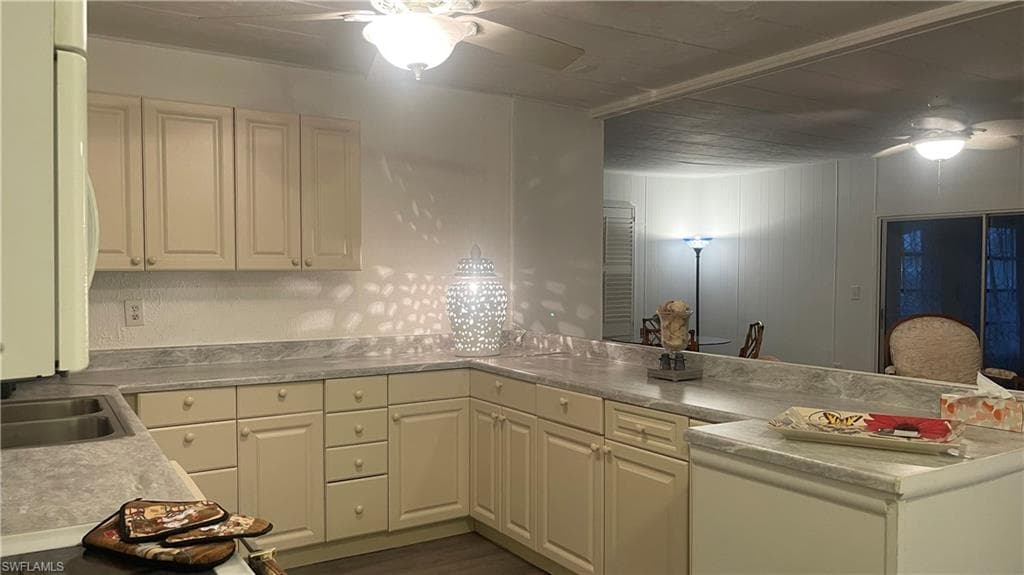 Kitchen with sink, white appliances, and ceiling fann