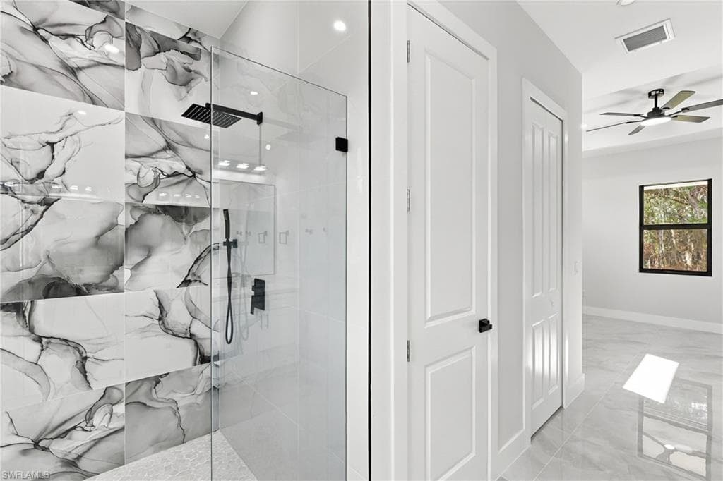 Walk-in shower with black-finish fixtures and patterned wall tile