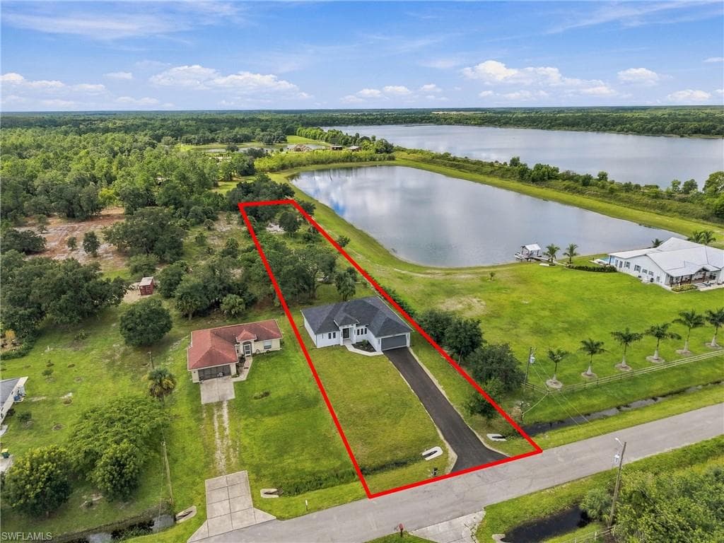 Single-story residence with an attached garage, paved driveway, and expansive green lawn