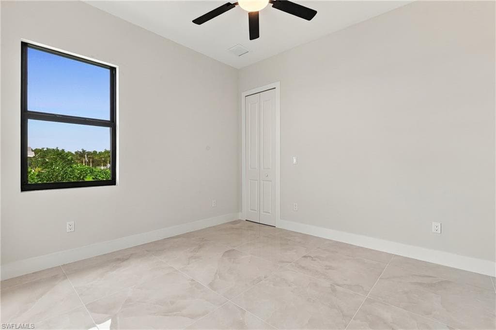 Recessed lighting, ceiling fan, bi-fold closet doors, large window, and tile flooring