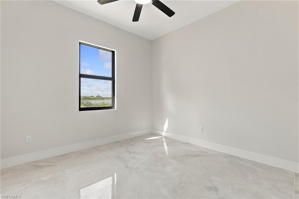 Neutral-toned walls, large format tile flooring, black-framed window, and a ceiling fan with integrated lighting