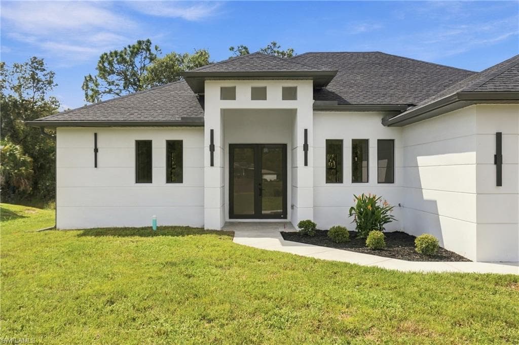 Contemporary stucco exterior with a gray shingle roof