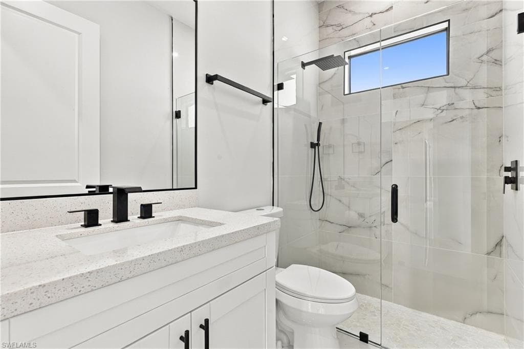 Vanity with white shaker-style cabinetry, white speckled countertop, and rectangular undermount sink