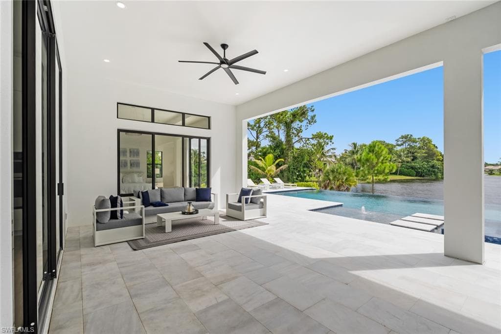 Expansive covered patio featuring large format tile flooring, a ceiling fan, and recessed lighting
