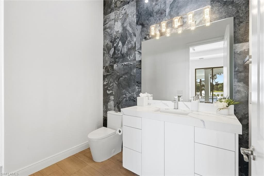 Modern vanity with a rectangular undermount sink, a white countertop, and a contemporary wall-mounted light fixture