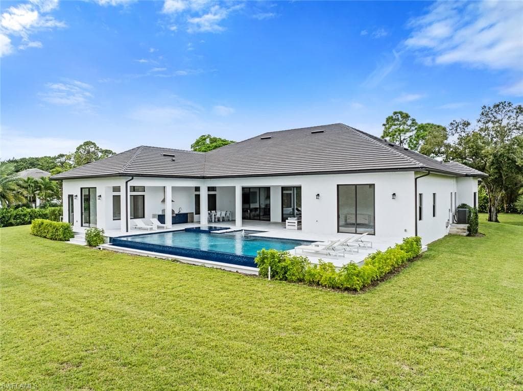 Modern exterior with a dark tiled roof, white stucco finish, and black-framed windows