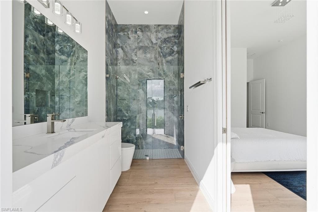 Contemporary bathroom with a floating vanity, single basin sink, and wood-finish flooring